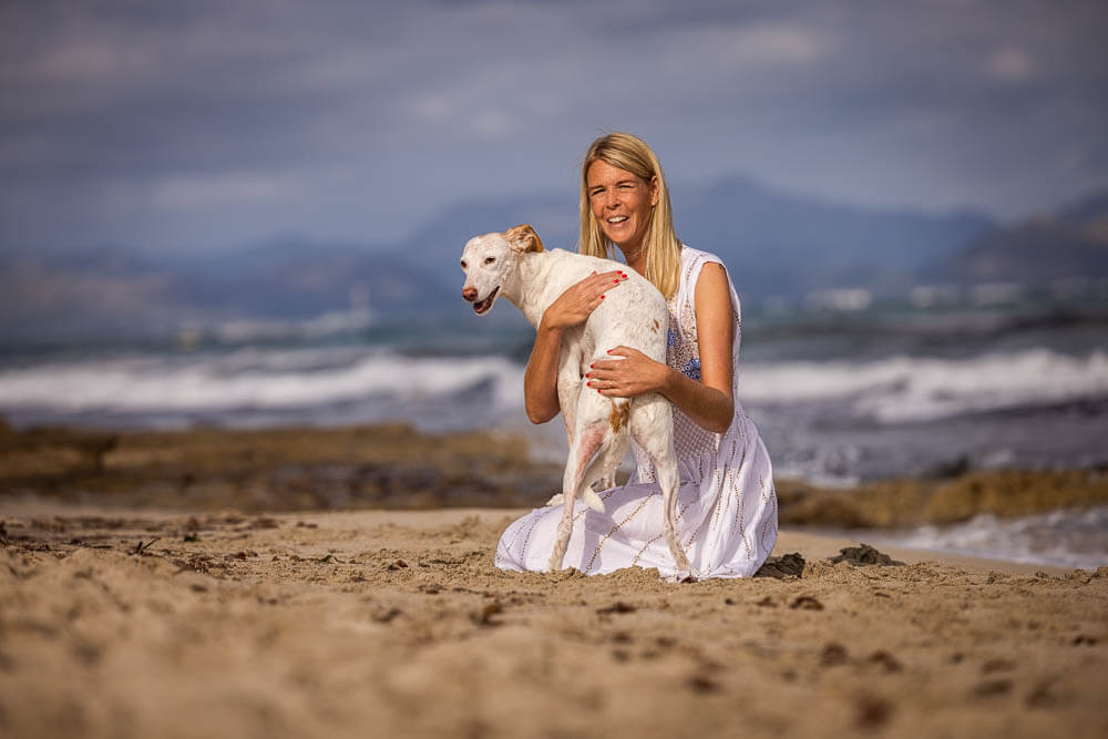 martina flocken - doggy fitness - hundephysio - hundefitness - martina flocken hält hund am strand und zeigt liebevolle bindung